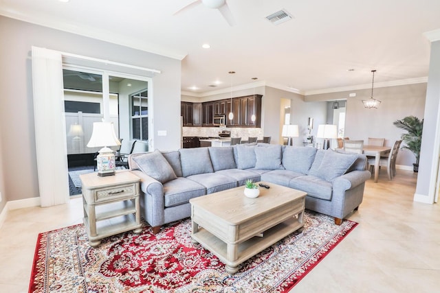 living area featuring visible vents, ceiling fan with notable chandelier, crown molding, and baseboards