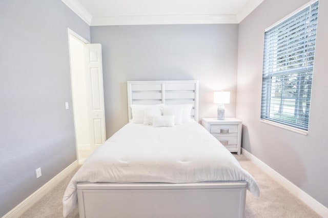 bedroom featuring baseboards, light colored carpet, and crown molding