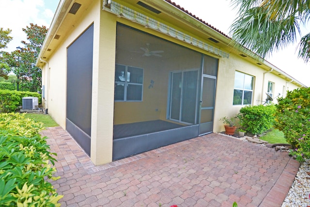 rear view of house featuring cooling unit, ceiling fan, a patio area, and a sunroom