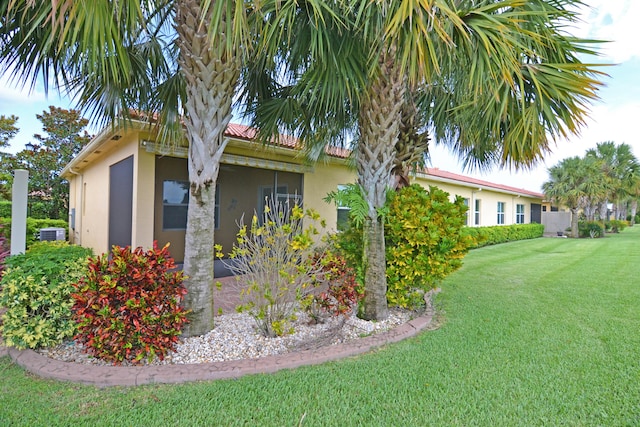 view of property exterior featuring a yard, cooling unit, and stucco siding