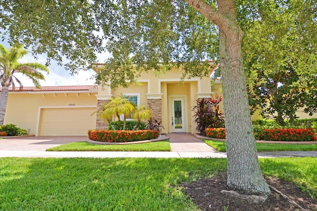 view of front of property featuring stucco siding, a front lawn, a tile roof, concrete driveway, and an attached garage