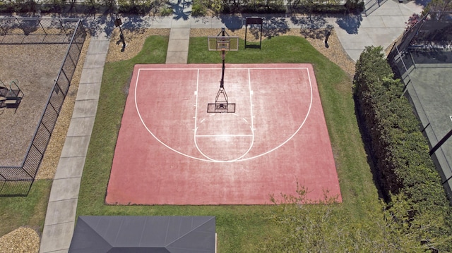 view of basketball court with a yard, community basketball court, and fence