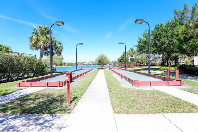 view of community with a water view and a lawn