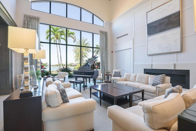 living area with a high ceiling, a fireplace, and a wealth of natural light