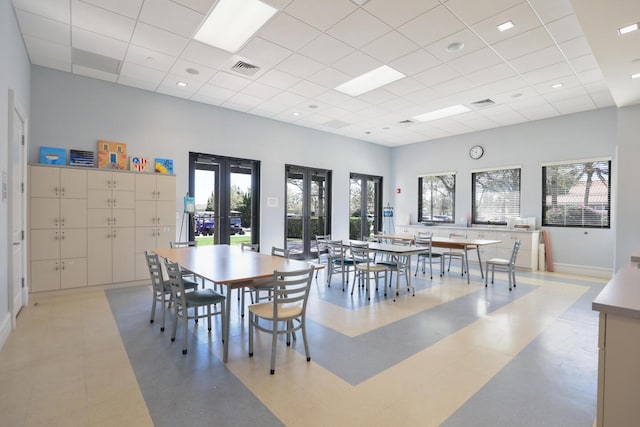 dining room with french doors, a high ceiling, a healthy amount of sunlight, and visible vents