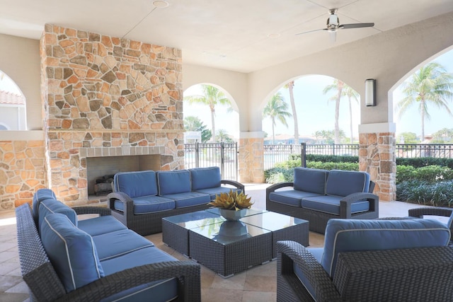 view of patio / terrace featuring ceiling fan and an outdoor living space with a fireplace