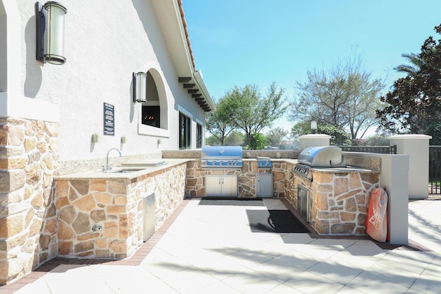 view of patio / terrace featuring an outdoor kitchen, a grill, and a sink