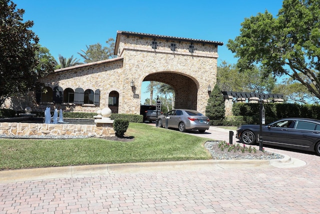 view of front of home featuring a front lawn and stone siding