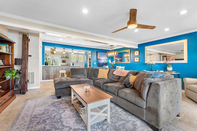 living room with ceiling fan with notable chandelier and crown molding