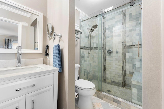 bathroom featuring crown molding, vanity, a shower with shower door, and toilet