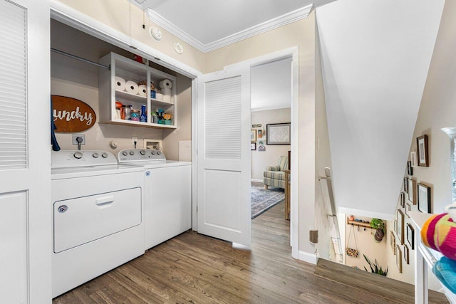 washroom with dark hardwood / wood-style flooring, washing machine and dryer, and crown molding