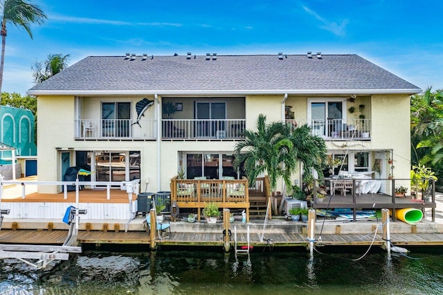 back of property with a water view and a balcony