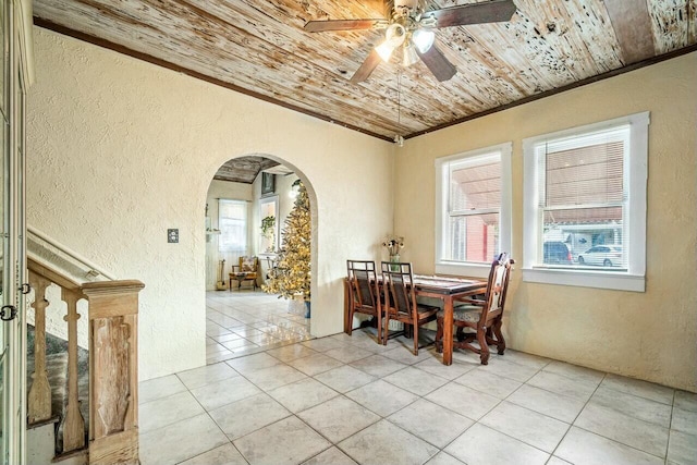 tiled dining area with ceiling fan, crown molding, and wooden ceiling