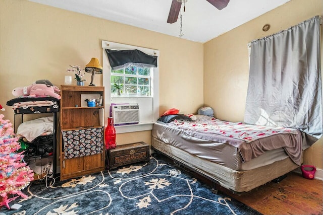 bedroom featuring ceiling fan, cooling unit, and wood-type flooring