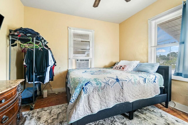 bedroom with ceiling fan, cooling unit, and hardwood / wood-style flooring