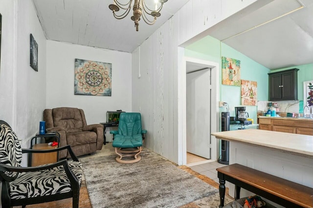 living area featuring a notable chandelier, light tile patterned flooring, lofted ceiling, and sink