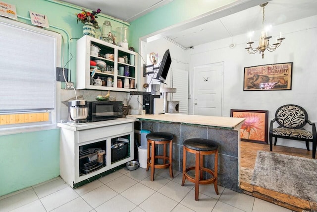 kitchen with a notable chandelier, kitchen peninsula, and a breakfast bar area