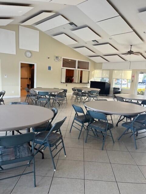 dining area with ceiling fan, light tile patterned floors, and lofted ceiling