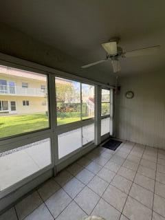 unfurnished sunroom with ceiling fan