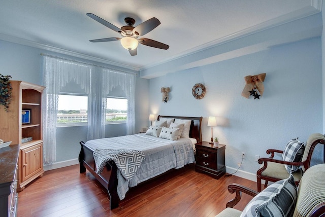 bedroom with hardwood / wood-style flooring, ceiling fan, and crown molding