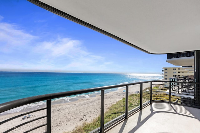 balcony featuring a water view and a view of the beach