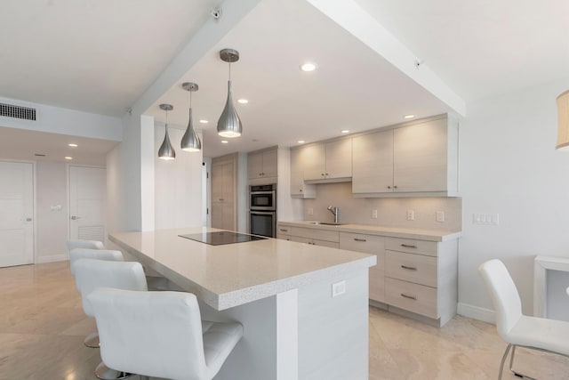 kitchen featuring pendant lighting, backsplash, a kitchen breakfast bar, black electric cooktop, and double oven