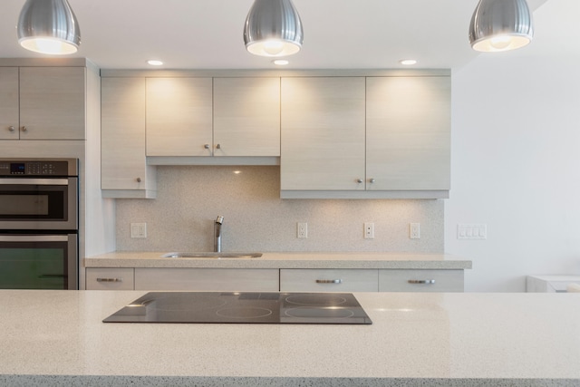 kitchen with sink, tasteful backsplash, double oven, pendant lighting, and black electric stovetop