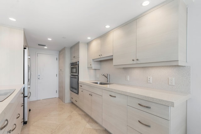 kitchen with appliances with stainless steel finishes, backsplash, and sink