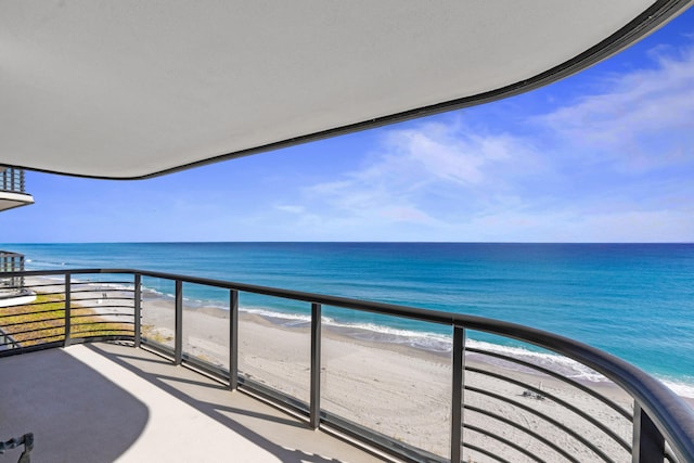 balcony featuring a water view and a beach view