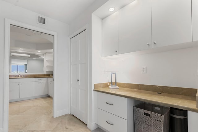 interior space with sink and white cabinets