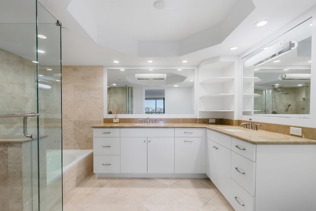 bathroom featuring tile patterned flooring, vanity, a tray ceiling, and independent shower and bath