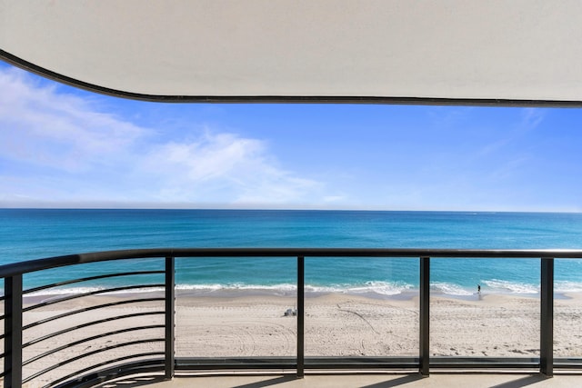 balcony with a water view and a beach view