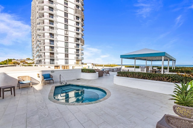 view of pool featuring a gazebo, a patio, and a hot tub