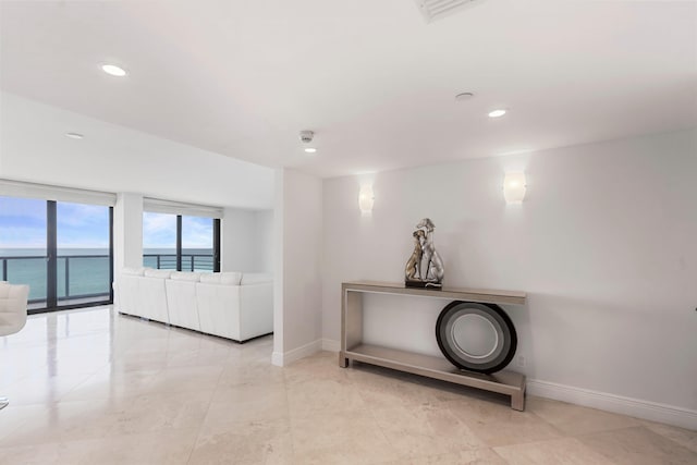 interior space with a water view and floor to ceiling windows