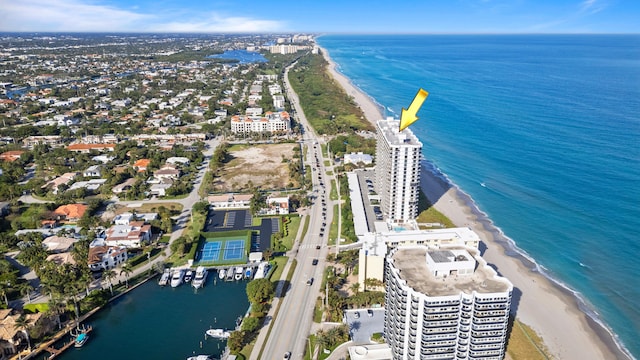 birds eye view of property with a water view and a beach view