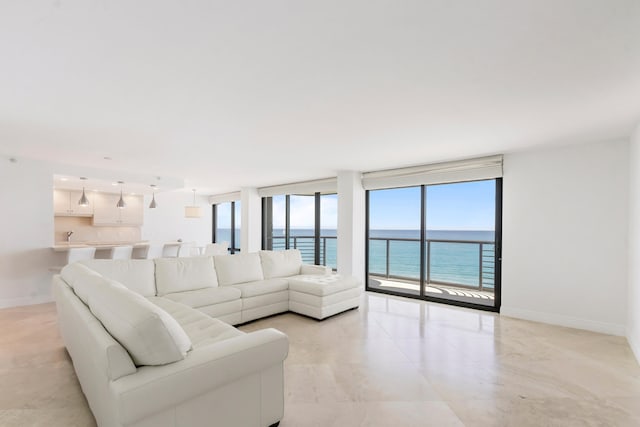 living room featuring a water view, plenty of natural light, and expansive windows