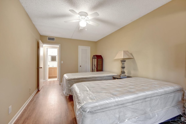 bedroom with ceiling fan, a closet, a textured ceiling, and light wood-type flooring