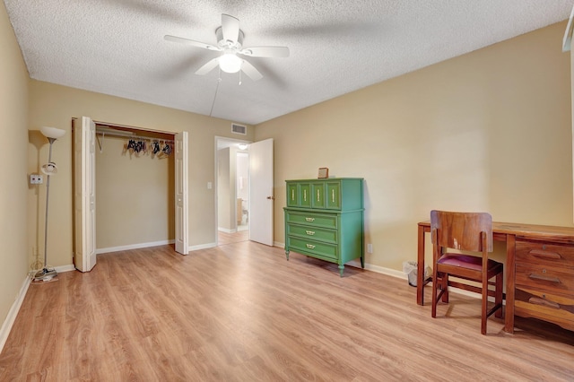 sitting room with a textured ceiling, light hardwood / wood-style floors, and ceiling fan