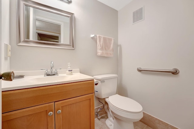 bathroom with tile patterned flooring, vanity, and toilet