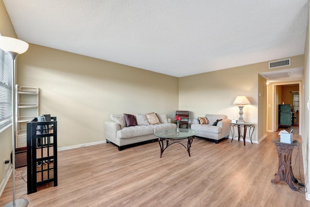 living room with light hardwood / wood-style floors and a textured ceiling