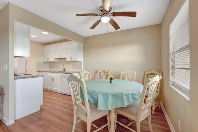 dining room with a textured ceiling, light hardwood / wood-style floors, ceiling fan, and sink