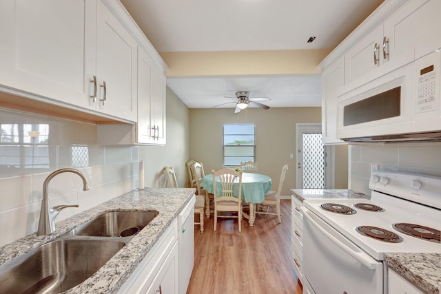 kitchen featuring white appliances, white cabinets, sink, decorative backsplash, and light wood-type flooring