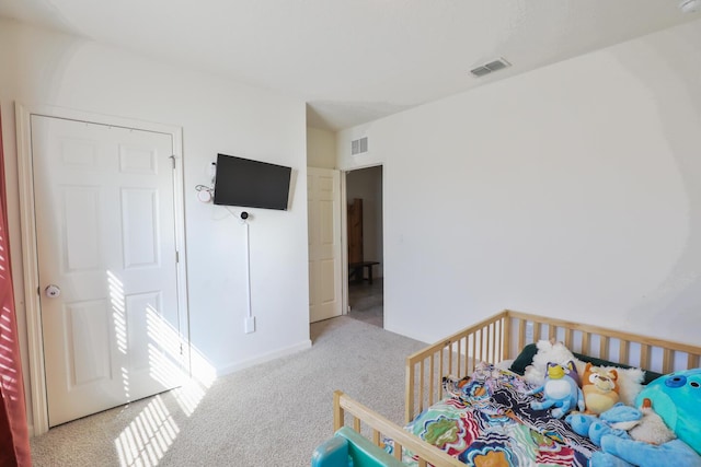 carpeted bedroom featuring a crib