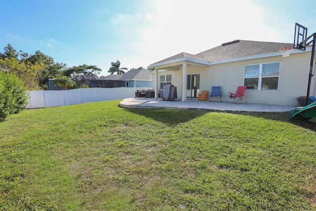 rear view of property featuring a lawn and a patio