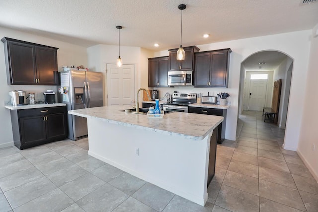 kitchen featuring hanging light fixtures, sink, an island with sink, and appliances with stainless steel finishes