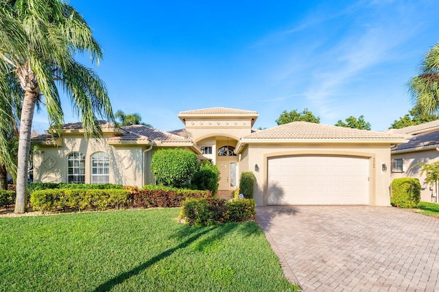 mediterranean / spanish home featuring a front lawn and a garage