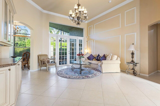 tiled living room with french doors, a towering ceiling, ornamental molding, and an inviting chandelier