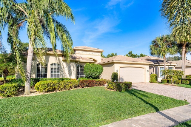 mediterranean / spanish house with a garage and a front yard