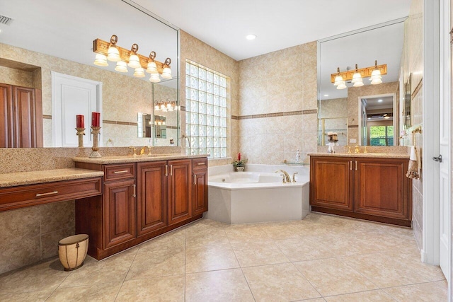 bathroom with tile patterned flooring, vanity, a healthy amount of sunlight, and tile walls