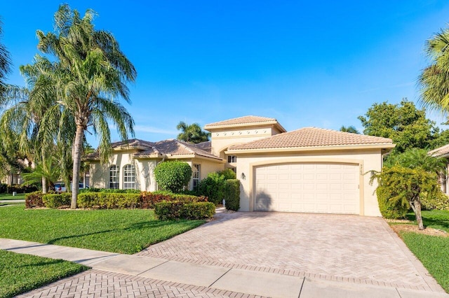 mediterranean / spanish house featuring a garage and a front lawn